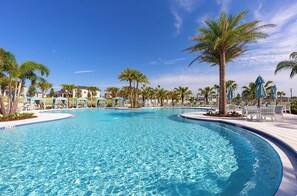 A large, clear swimming pool surrounded by palm trees and lounge chairs. - Disney Home w/Private Pool - Resort Fun Sleeps 10 (Kissimmee)