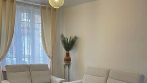 A modern living room with two sofas, a coffee table, and two yellow armchairs. - Le confort avec jardin, à deux pas du port (Fécamp)