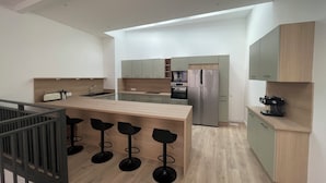 A modern kitchen with a central island, bar stools, and built-in appliances. - Town house, 4 bedrooms / 4 bathrooms, large living room and terrace (CARCASSONNE)