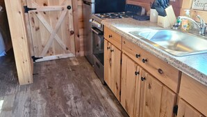 Una cocina con armarios de madera, estufa, horno y lavaplatos.