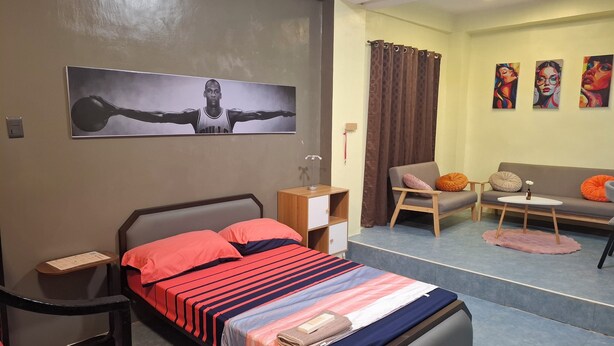 Una habitación de hotel con cama, escritorio, silla, sofá y una mesita.