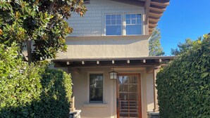 A two-story house with a front porch, stone pillars, and a wooden door. - Lovely 4-bedroom house in  charming Coronado, "The Golden Triangle" (Coronado)