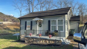 A single-story house with a front porch, a stone foundation, and a mailbox. - Cozy 2-bedroom house in beautiful Andrews,NC with theater room and air hockey. (Andrews)
