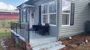 A house with a porch, two chairs, and a welcome sign. - Cozy 2-bedroom house in beautiful Andrews,NC with theater room and air hockey. (Andrews)