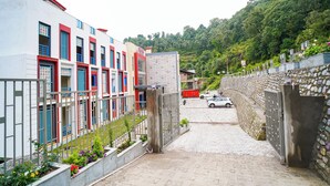 A narrow cobblestone street flanked by multi-story buildings with balconies and flower boxes. - Sukama Resort & Spa (Dhari)