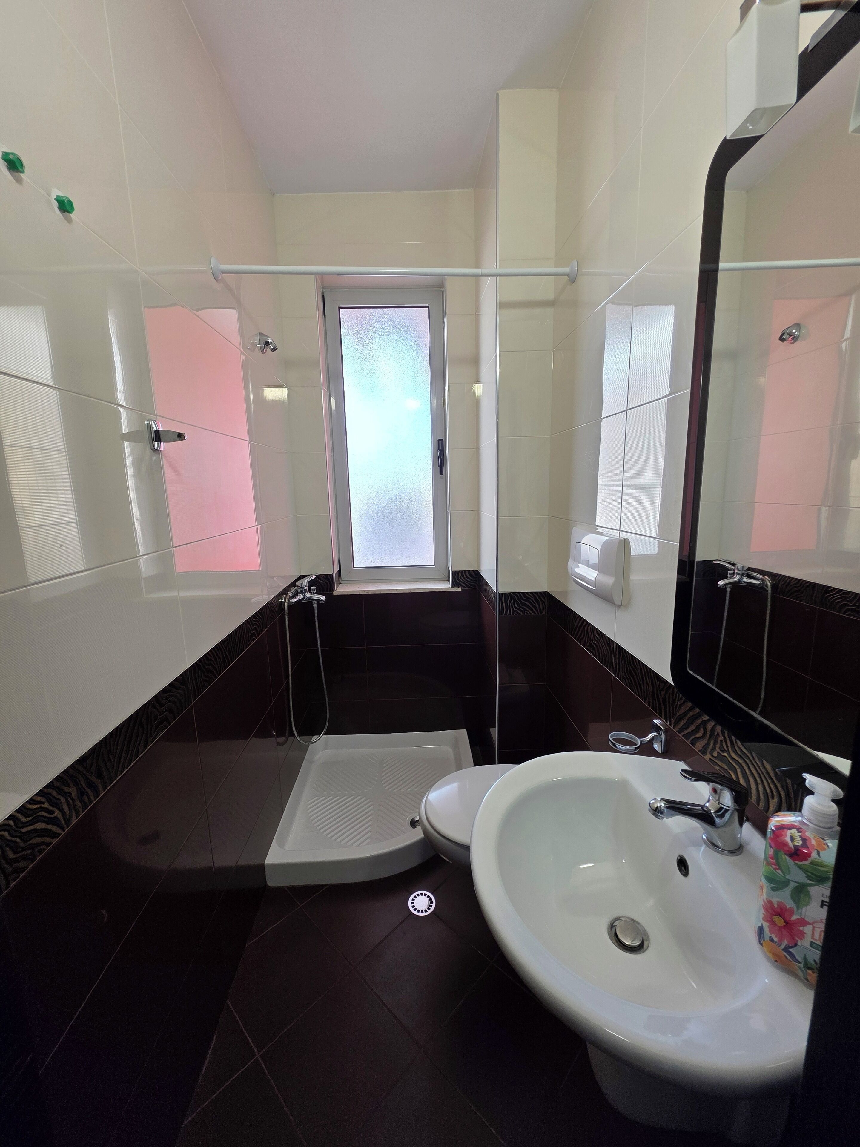 A bathroom with a shower, a toilet, and a sink.