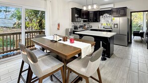 Una cocina moderna con zona de comedor, ventanas amplias y vistas al exterior.