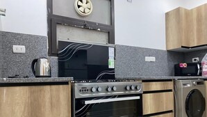 A modern kitchen with a built-in oven, microwave, and washing machine. - 3-bedroom apartment in perfect  Giza Governorate, Beverly Hills, Sheikh Zayed. (Giza Governorate)