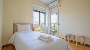 A bedroom with a bed, a window, a radiator, and a balcony. - Sunlit Terrace 3BR Apartment – Tavros by ΜΡS (Tavros)
