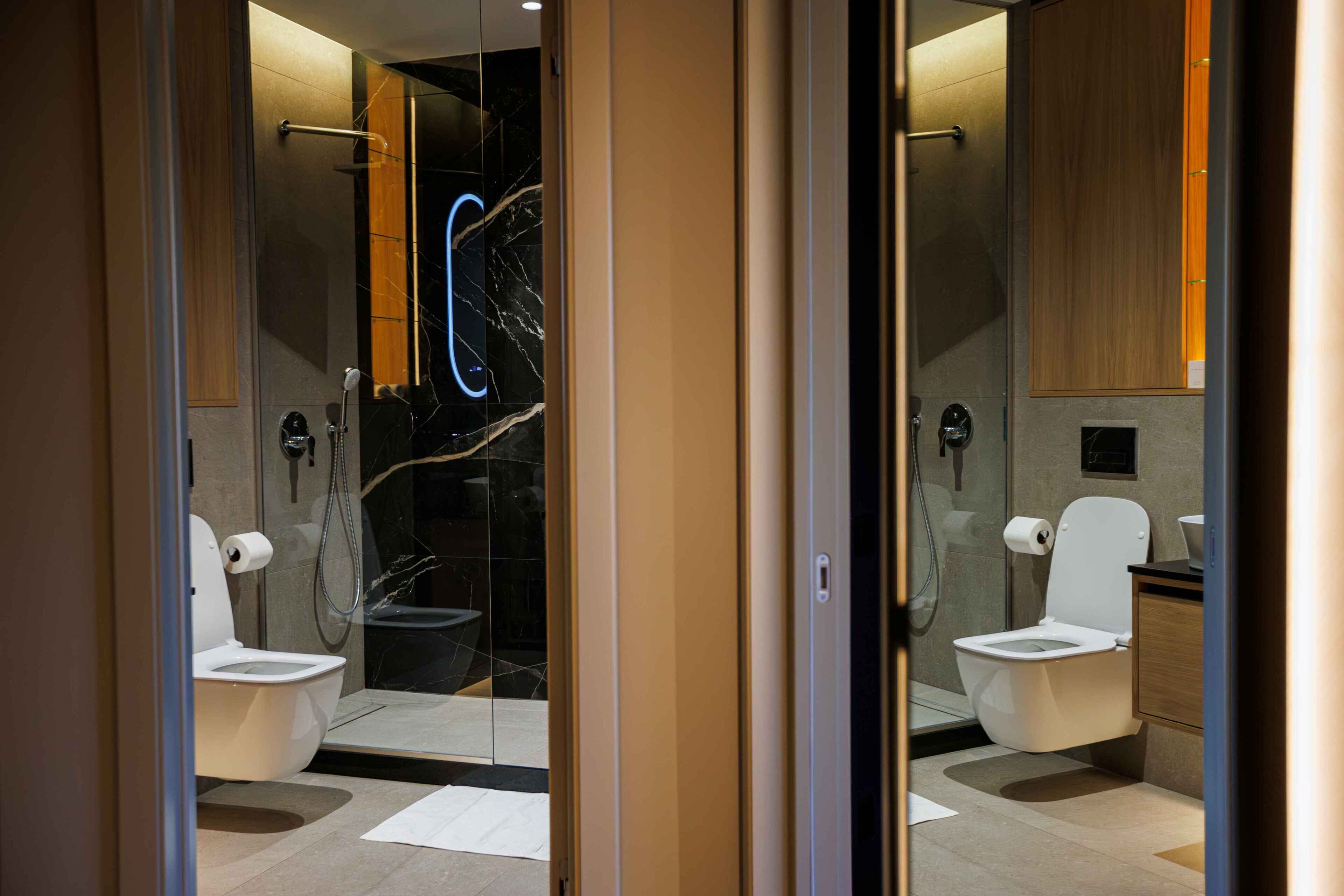 Une salle de bain moderne avec une douche à parois de verre, des toilettes et un lavabo.