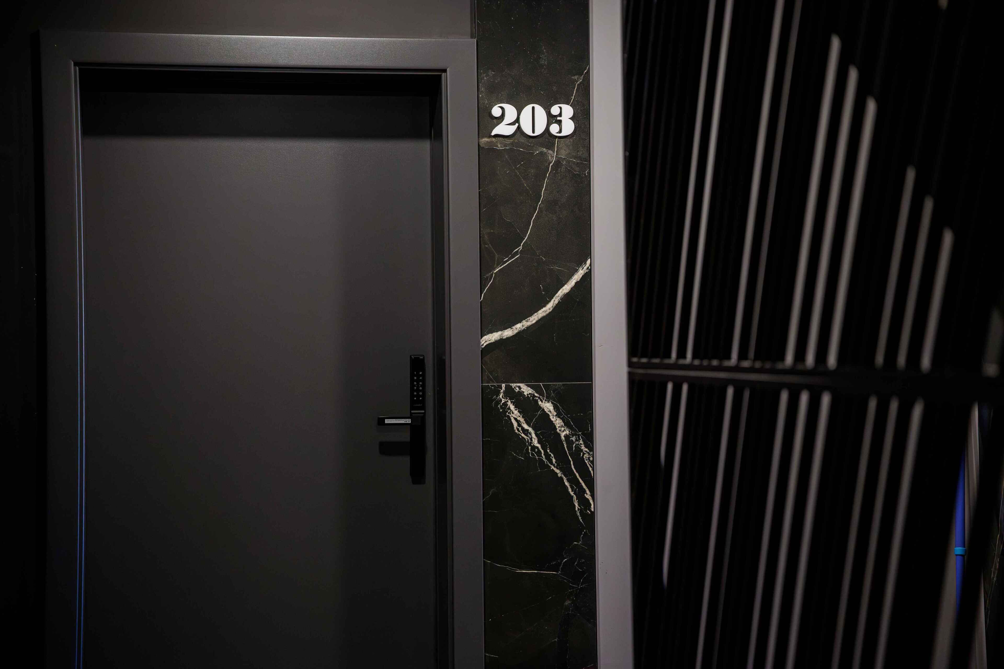 Eine Tür mit der Nummer 203 und einem Ziffernschloss.