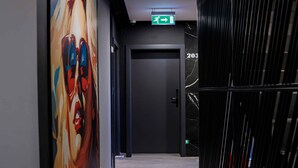 A hallway with a large abstract mural, a door with a number, and a metal partition. - D'otel 47 (Cluj-Napoca)