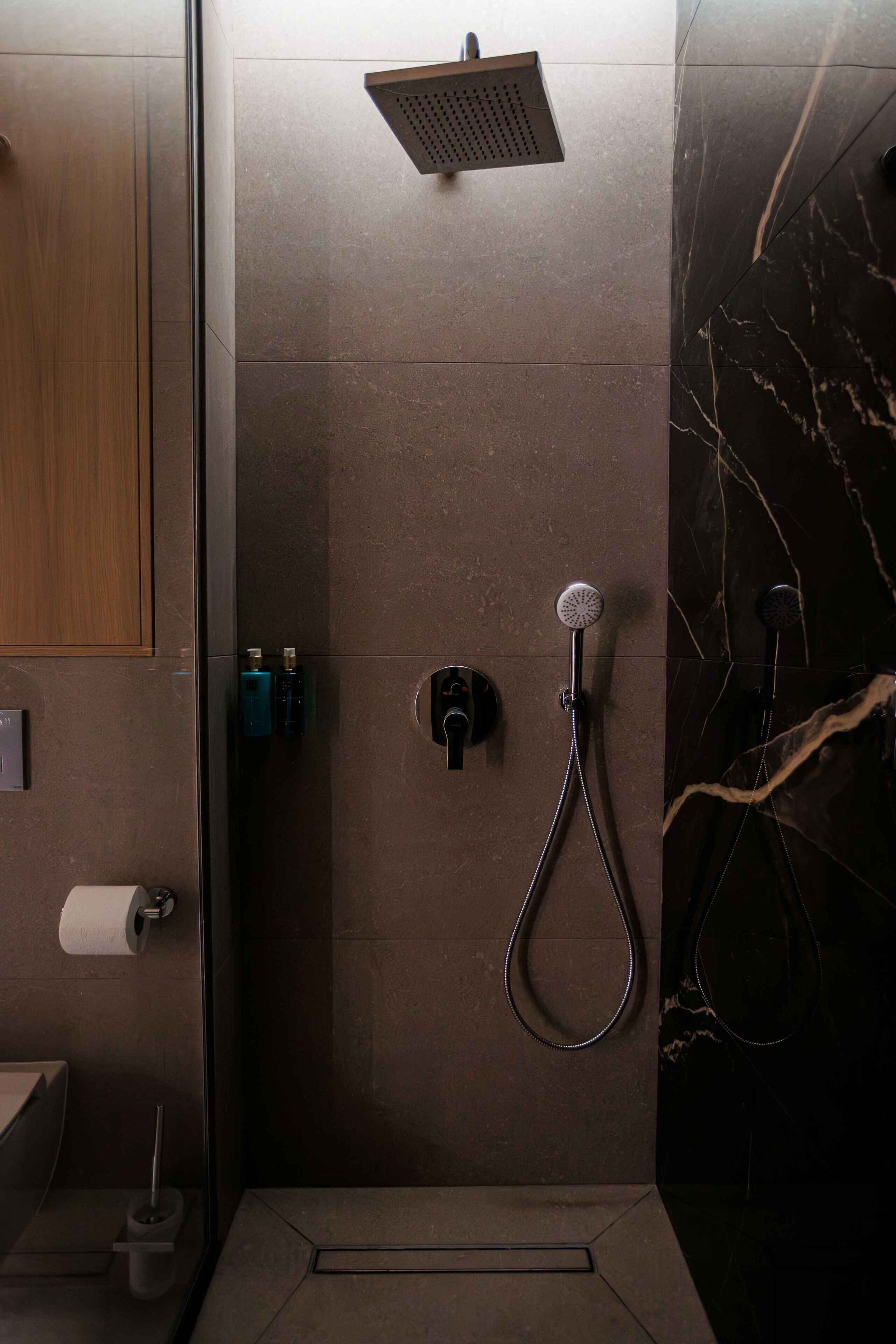 A modern bathroom with a shower, toilet, and hand dryer.