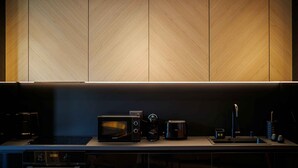 A modern kitchen with a built-in microwave, coffee maker, and toaster. - D'otel 47 (Cluj-Napoca)