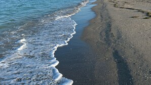 Ein Strand mit blauem Himmel und ruhiger See.