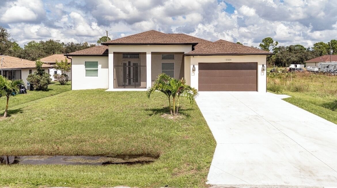 A single-story house with a garage, a front lawn, and a small water feature.