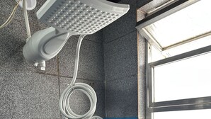 A bathroom with a shower, a window, and a towel rack. - Seu cantinho na Gamboa (Cabo Frio)