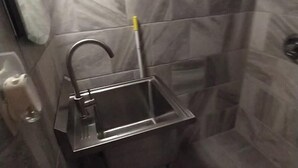 Un baño con lavamanos, espejo y paredes con azulejos.