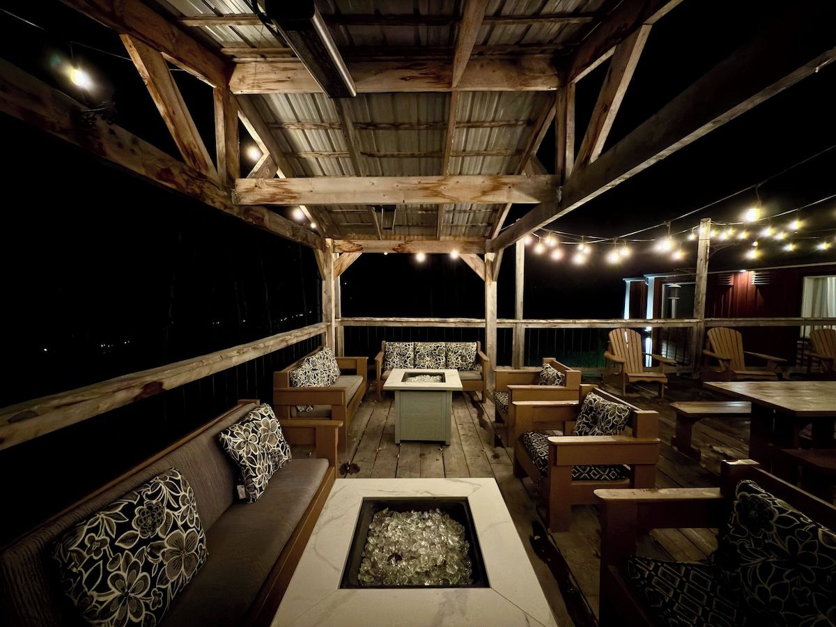 An outdoor seating area with wooden furniture and a fire pit.