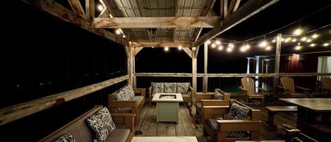 An outdoor seating area with wooden furniture and a fire pit.