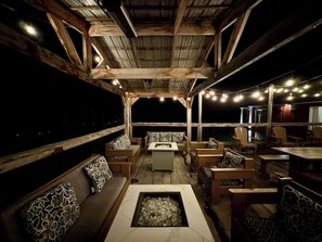 An outdoor seating area with wooden furniture and a fire pit.