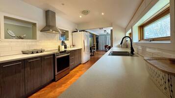 A modern kitchen with a central island, stainless steel appliances, and a view of the dining area.