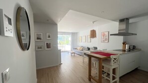 Eine moderne Küche mit Essbereich, Holzboden und einem großen Fenster.