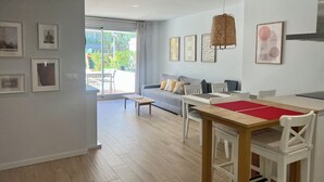 Ein modernes Wohnzimmer mit einer Couch, einem Esstisch und Kunstwerken an den Wänden.