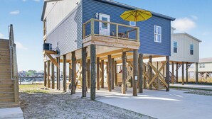 Een huis met twee verdiepingen, een balkon en een houten terras.