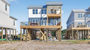 Een meerlaags houten gebouw met een balkon op de begane grond, gebouwd op houten poten.