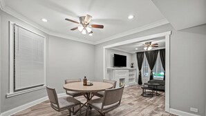 A dining area with a round table and chairs, a ceiling fan, and a fireplace. - Beautiful Bollywood 3 Bed Gem near Loyola University/Rogers Park/Lake Michigan (Chicago)
