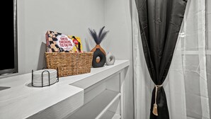 A neatly organized room with a white console table holding a chess set, a basket, and a decorative vase. - Beautiful Bollywood 3 Bed Gem near Loyola University/Rogers Park/Lake Michigan (Chicago)