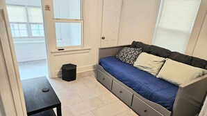 A compact room with a bed, a small table, and a trash bin. - Apartment located in vibrant Montclair 2-blocks to NYC trains (Montclair)