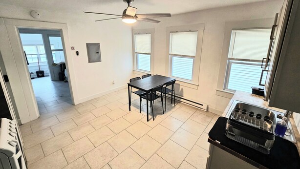 A spacious kitchen with a dining area, a ceiling fan, and a view of the backyard. - Apartment located in vibrant Montclair 2-blocks to NYC trains (Montclair)