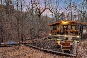 Un chalet rustique doté d’une terrasse, d’un foyer et d’un espace salon extérieur.