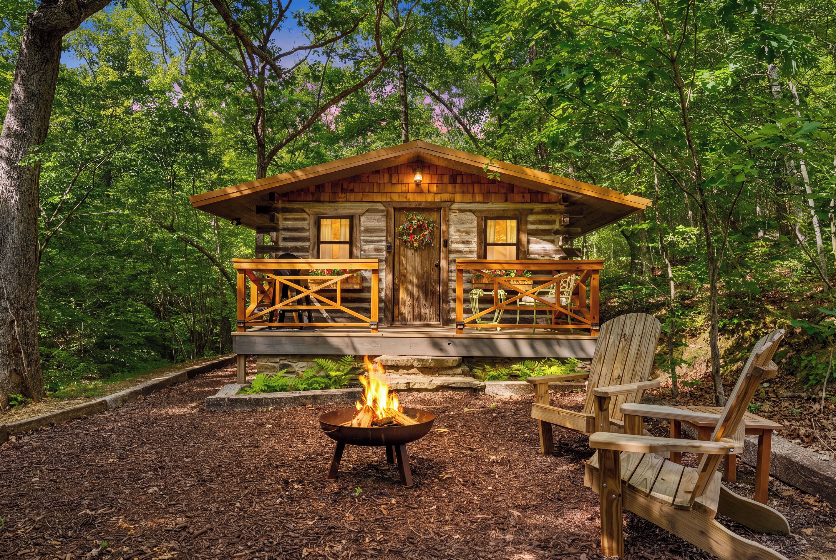 Eine Holzblockhütte mit einer Terrasse, einer Feuerstelle und einem Stuhl.