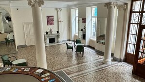 A spacious lobby with high ceilings, a fireplace, and a reception desk with brochures. - Family apartment for 4 in the heart of La Bourboule (La Bourboule)