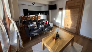 A living room with a sofa set, a coffee table, and a TV. - Cozy apartment in Châtel with balcony, 3 bedrooms, wifi, garage (Châtel)