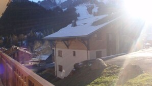 A mountain cabin with a sloped roof, surrounded by snow-covered mountains and a clear sky. - Cozy apartment in Châtel with balcony, 3 bedrooms, wifi, garage (Châtel)