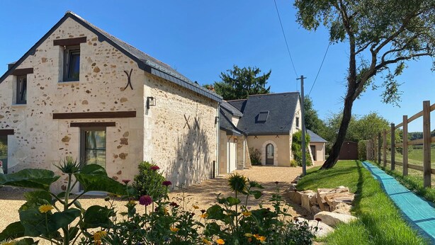 A rustic stone building with a sloped roof, a small attached structure, and a wooden fence. - Cozy countryside cottage, 2 bedrooms, open views (Baugé en Anjou)
