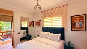 Ein Schlafzimmer mit einem großen Bett, einer Deckenleuchte und Kunstwerken an den Wänden.