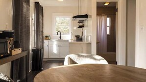 A modern kitchen with white cabinets, a black faucet, and a window above the sink. - Yosemite Cottage Retreat: 1/2 Block to Downtown (Mariposa)