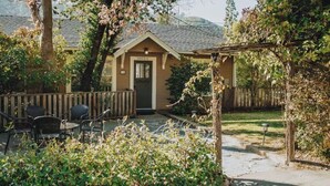 A small, single-story building with a front door labeled "5053 A" and a covered patio area with chairs. - Yosemite Cottage Retreat: 1/2 Block to Downtown (Mariposa)