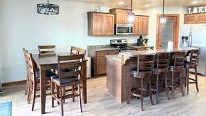 Una cocina con armarios de madera, una isla central y taburetes de bar.