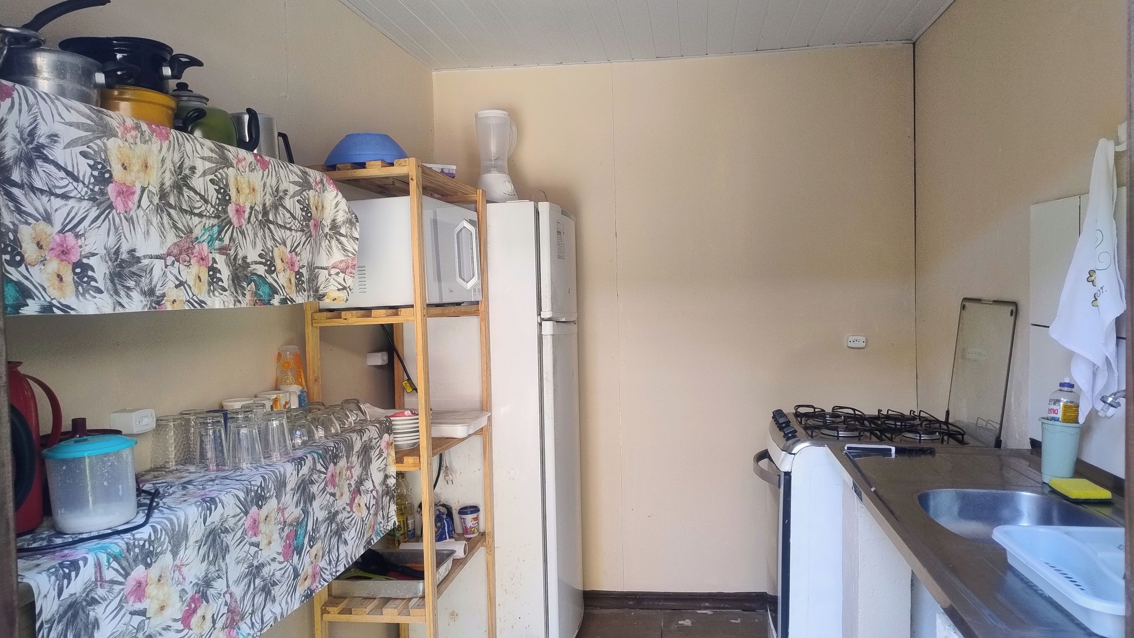Kompakti keittiö, jossa on jääkaappi, kaasuliesi ja perusvarusteet.