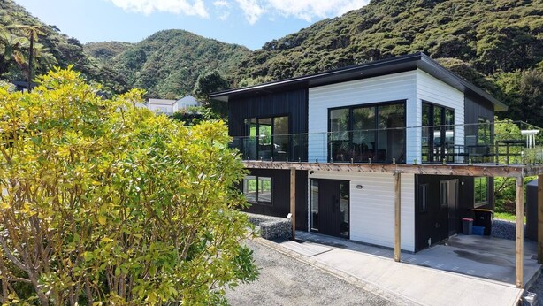 Een modern huis met twee verdiepingen, grote ramen, een balkon en een garage.