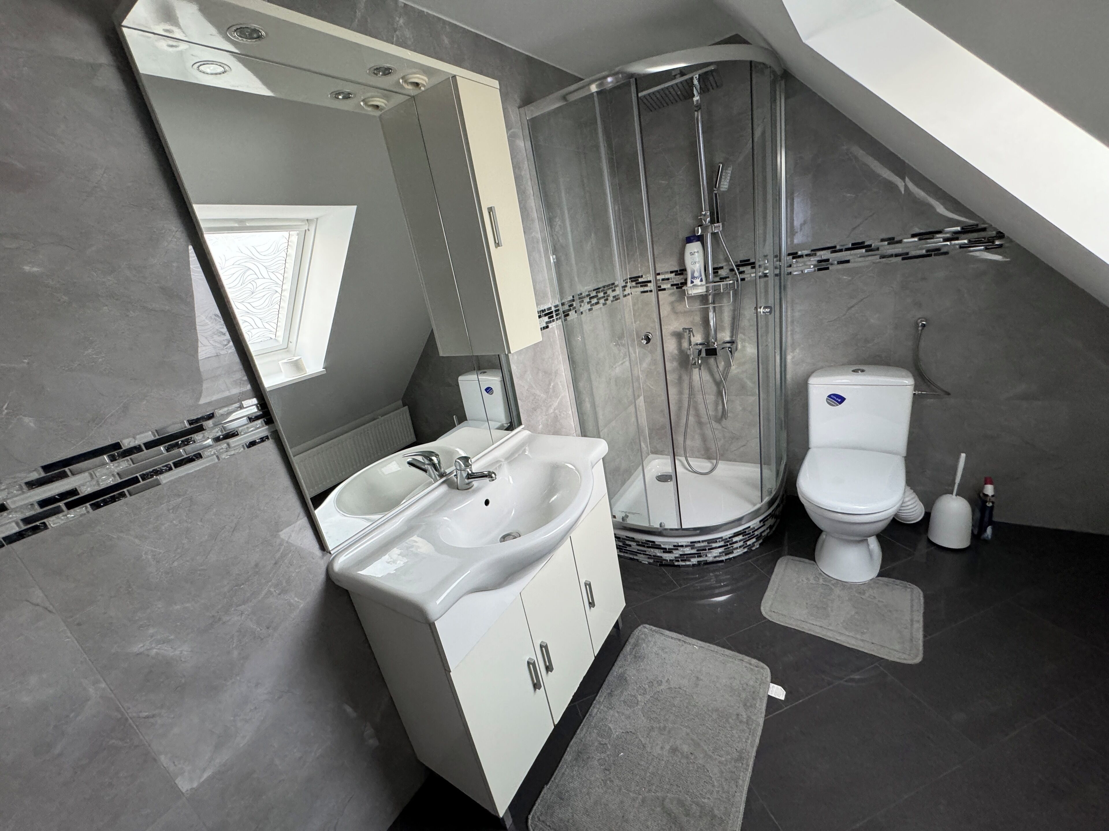 Ein modernes Badezimmer mit Dusche, Toilette und Waschbecken.