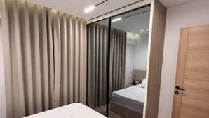 Een moderne slaapkamer met een bed, een kledingkast en een schuifdeurkast.