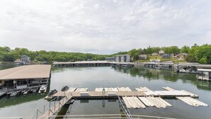A marina with docks and boats, surrounded by residential buildings and greenery. - Beautifully Updated Lakefront Condo – Cozy, Quiet, and Close to the Action! (Osage Beach)