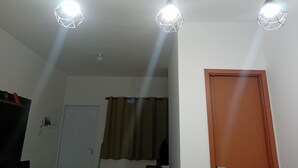 A room with three pendant lights, a door, and a curtain.